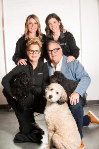 a family photo of the reid family, owners of haddon equipment and chemicals. two daughters brooke and marley, owners charles and julie and their three dogs